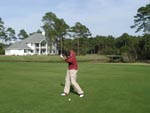 Here I am attempting a fairway shot on the seventh hole. To give you some perspective on what an abysmal golfer I am, this is probably my third stroke. To elaborate further, I am probably only fifty yards from the tee here. Note the alligator basking in the back yard behind me. He's probably mocking me. Damn alligator.