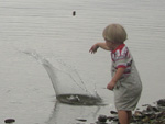 Somebody's little boy, throwing stones into the water